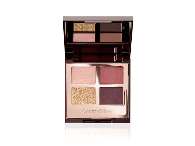 An open, mirrored-lid quad eyeshadow palette with eyeshadows in shades of golden, red, plum, and rose gold. 