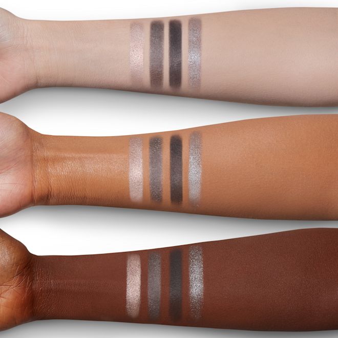 Luxury Palette in The Rock Chick arm swatches Four eyeshadow swatches in shades of grey, pearl, and silver on light, medium, and deep-tone arms.