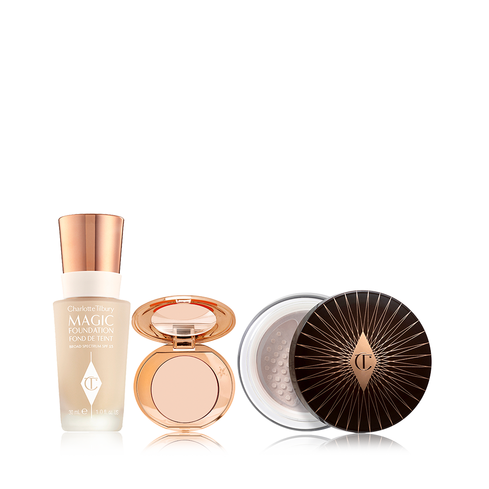 Foundation in a glass bottle with a gold-coloured lid, colour corrector compact in a light shade with a mirrored-lid, and loose setting powder with a black and gold-coloured lid. 