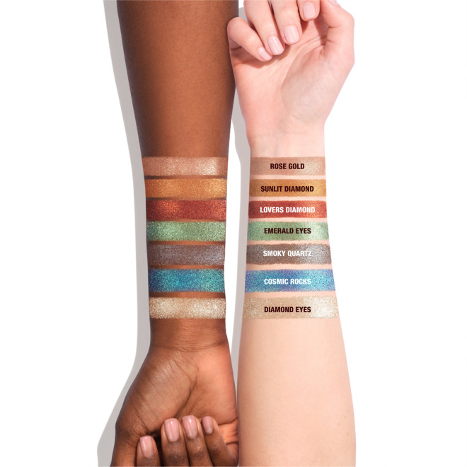 Light-tone arm with swatches of seven metallic eyeshadows in rose gold, bronze-orange, vibrant red, mint green, lilac-grey, sapphire blue, and opal.