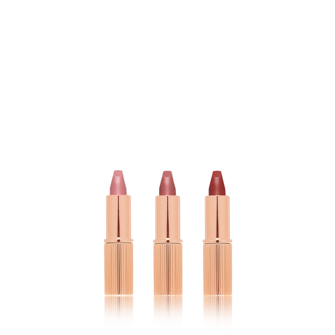Charlotte's Iconic Mini Lip Wardrobe open Three, open matte lipsticks in nude pink, pale pink, and berry-rose.