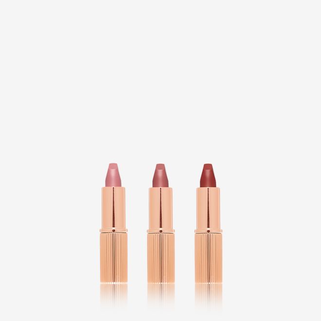 Charlotte's Iconic Mini Lip Wardrobe open Three, open matte lipsticks in nude pink, pale pink, and berry-rose.