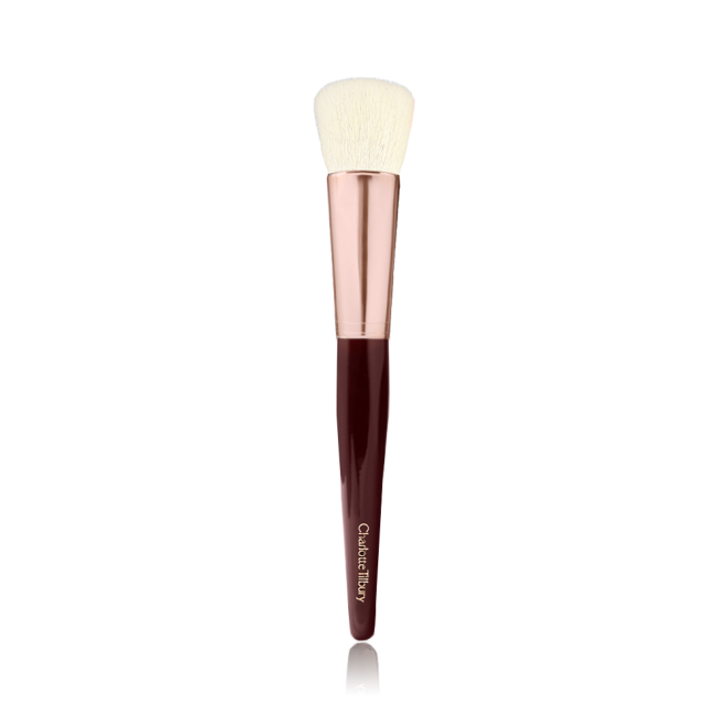 A face blending brush with cream-coloured bristles with a rose-gold and dark crimson handle. 