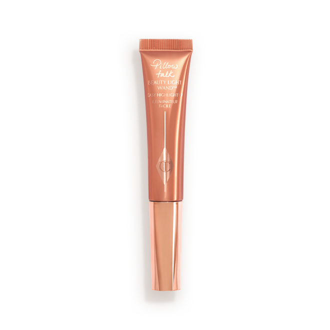 Beauty Light Wand highlighter in Pillow Talk Medium a highlighter wand, packaged in a reflective, peachy-pink tube with a rose gold cap.