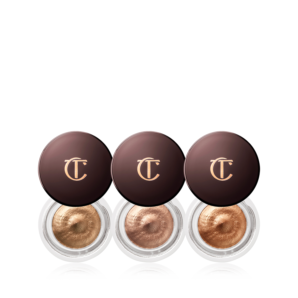 Three, petite, open pots filled with shimmery cream eyeshadows in nude, bronze, and rose gold.
