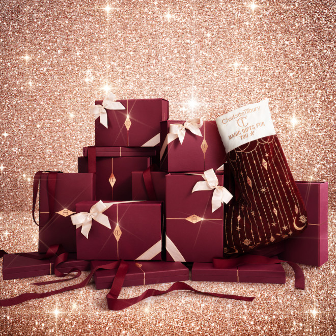 A large pile of gift boxes in maroon and gold with cream-coloured ribbons tied around them.