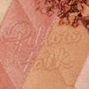 Close-up swatch of a pressed powder highlighter compact in various shades of pink and gold for warm-tone complexions. 