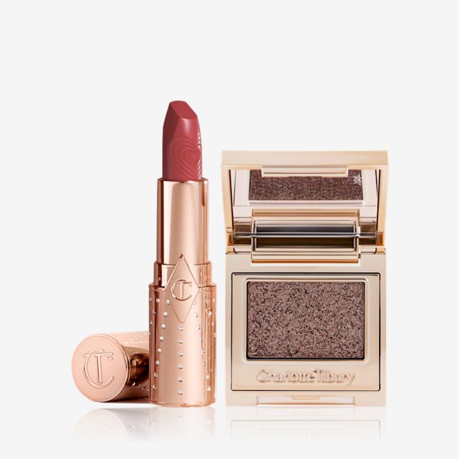Lip Eyes Hypnotise Kit open An open lipstick in a salmon-pink colour in a gold-coloured tube with a single-pan eyeshadow compact in an iridescent smokey grey eyeshadow with very fine shimmer.