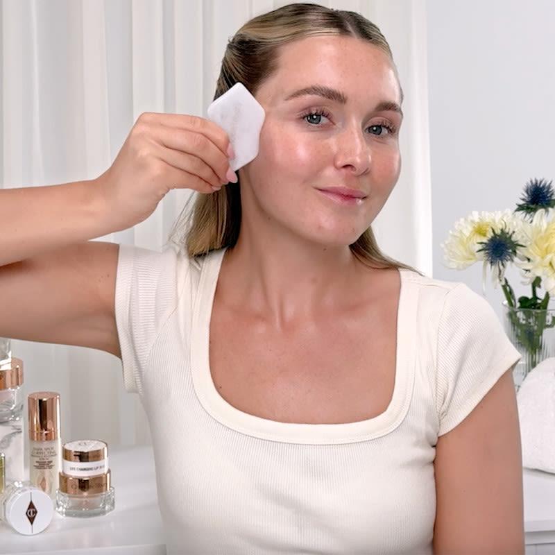 Model performing gua sha routine with skincare