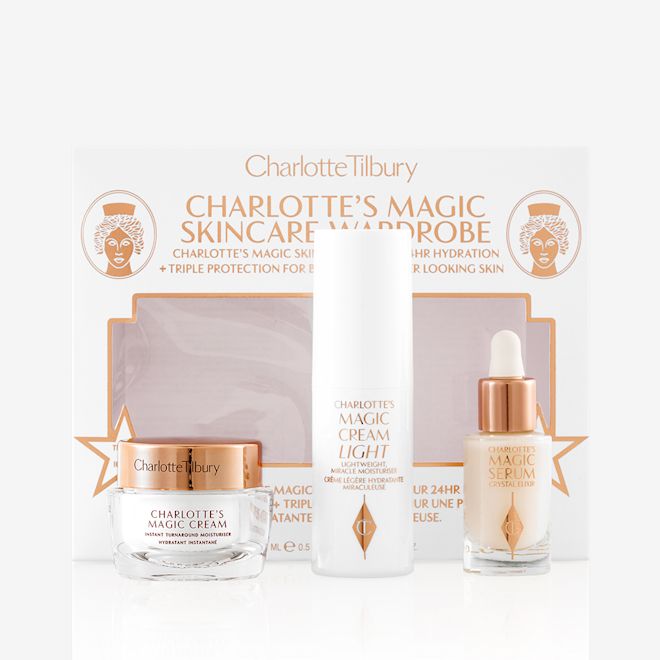 Magic Skincare Wardrobe removed from box Travel-size pearly-white cream in a glass jar with a gold-coloured lid, luminous serum in a glass bottle with a white and gold dropper lid, and face cream in a white-coloured bottle with their packaging box.