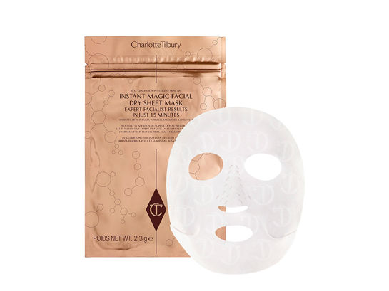 A dry sheet mask in textured fabric along with its golden-coloured foil packaging behind it. 
