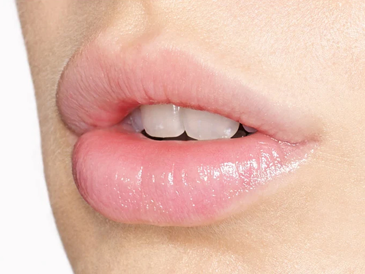 Gros plan sur les lèvres hydratées du modèle après avoir suivi la première étape de la routine d'application du crayon à lèvres de Charlotte.