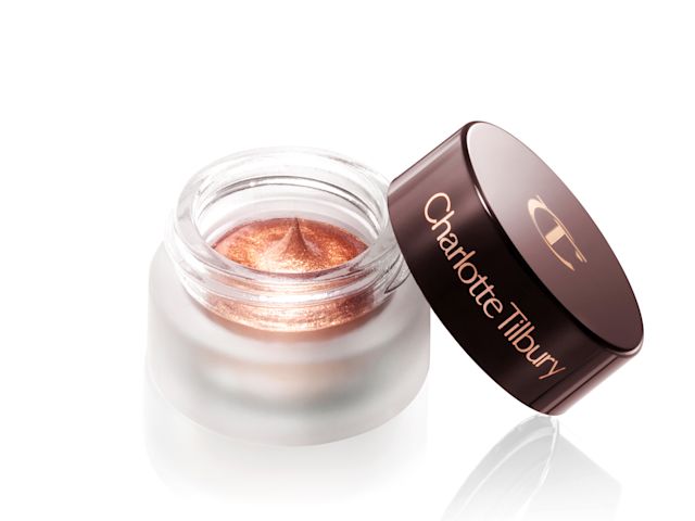 Russet rose cream eyeshadow with a golden-peach sparkle in a glass pot with the lid diagonally placed next to it.