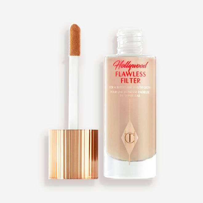 Hollywood Flawless Filter in shade 4.5 open An open, luminous primer in a light cool-toned-beige shade in a glass bottle with its gold and white doe-foot applicator next to it.