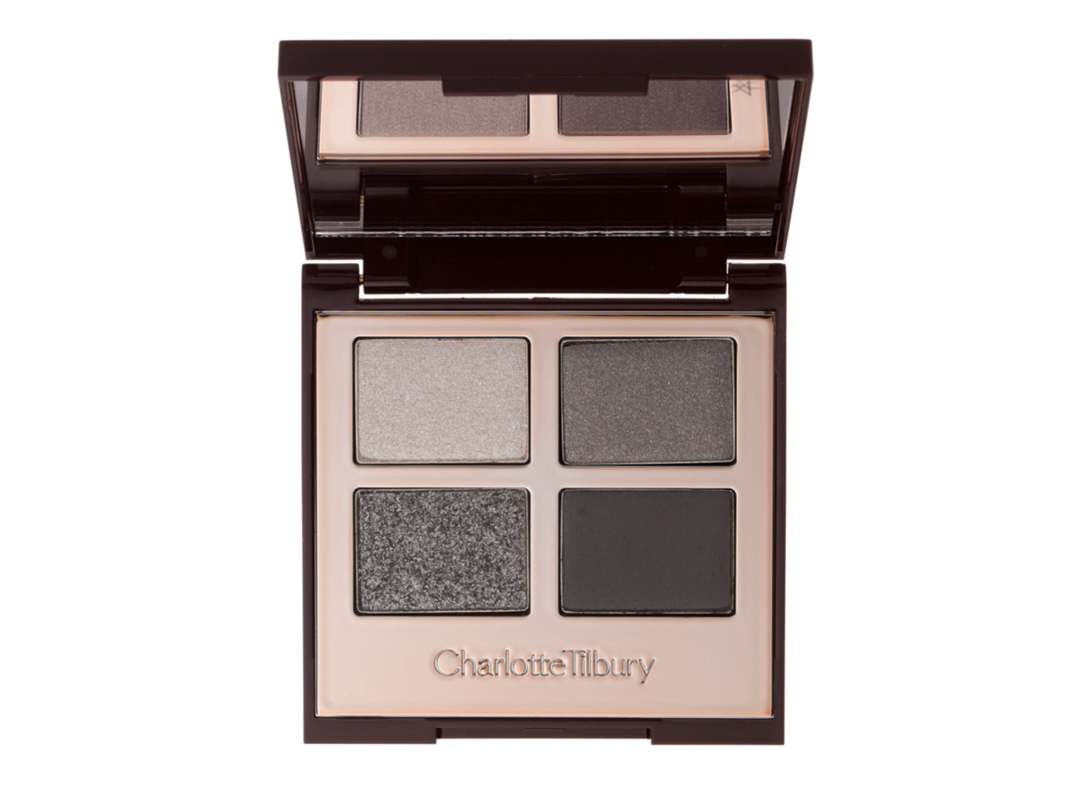 An open, mirrored-lid eyeshadow palette in matte and shimmery silver and grey shades.
