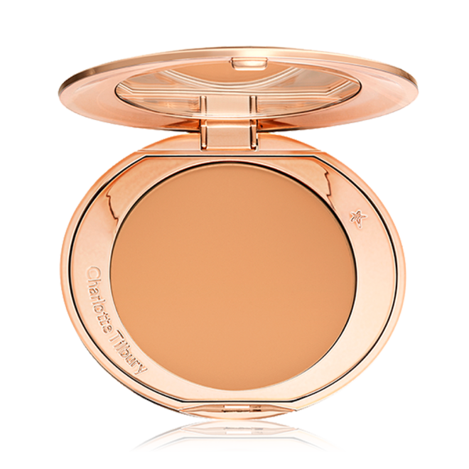 An open, pressed powder compact in a sandy-brown shade. 