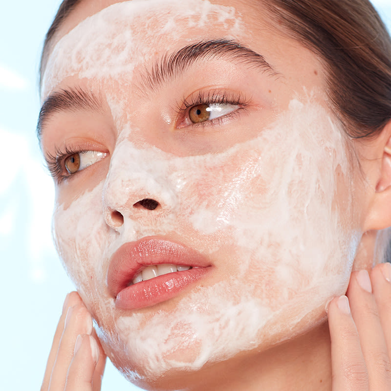 Modelo que muestra cómo lavarse la cara con el limpiador Magic Hydration Revival de Charlotte