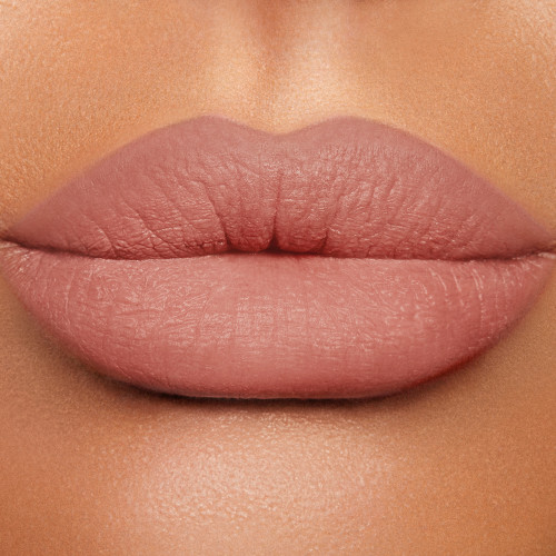 Lips close-up of a medium-tone model wearing a pigmented, matte, nude pink lip liner all over her lips.