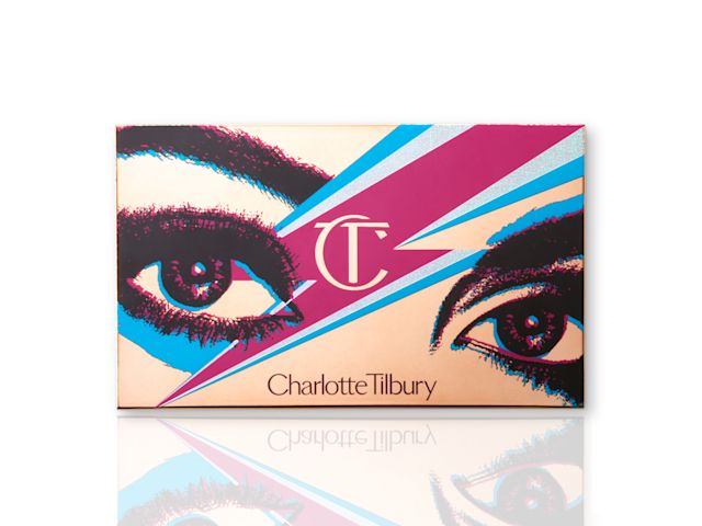 A closed eyeshadow palette with golden-coloured packaging and a lightning bolt in dark pink and blue colour on the lid along with an illustration of eyes in dark pink and black colour. 
