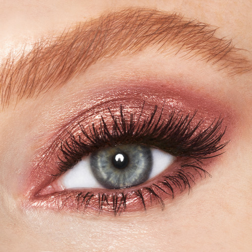 Close-up of a single blue eye with shimmery, rose-gold-coloured cream eyeshadow. 