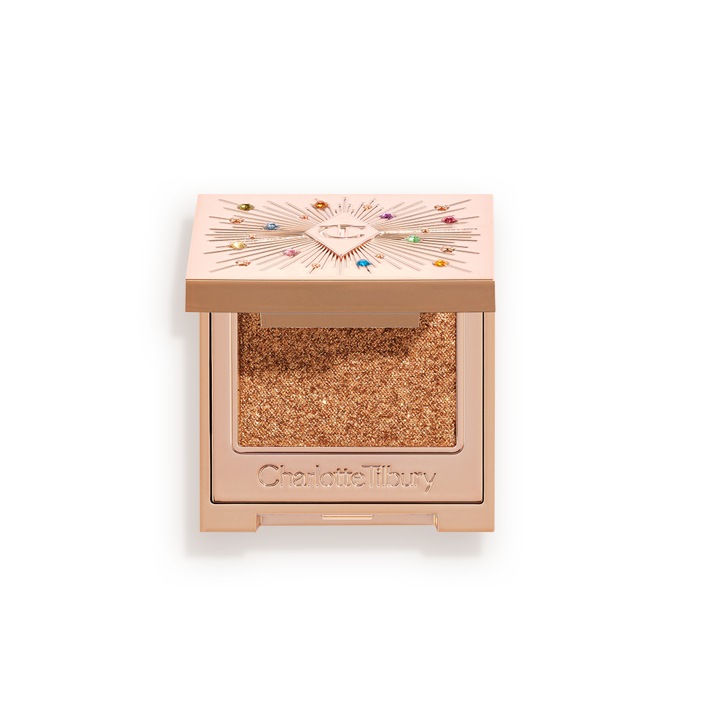 An open, single-pan eyeshadow with a mirrored lid in an iridescent orange-gold shade with very fine shimmer. 