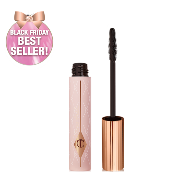 Mascara in a pink-coloured tube with its gold-coloured lid with a black applicator next to it. 