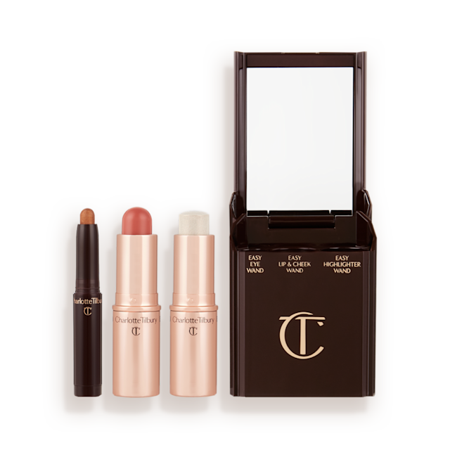 An open shadow stick in a shimmery bronze shade, lip and cheek blush stick in a nude-rose shade, and highlighter stick in an opal shade.