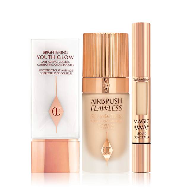 A primer in white and rose gold packaging with a foundation in a frosted glass bottle and rose-gold lid, and a concealer in rose-gold packaging with a small window on the tube to see the concealer shade.