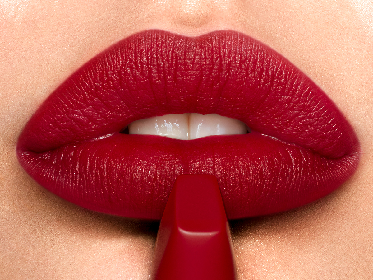 Model wearing Matte Revolution lipstick in Red Carpet Red to create a red-carpet lipstick look