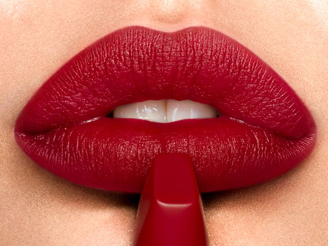 Model wearing Matte Revolution lipstick in Red Carpet Red to create a red-carpet lipstick look
