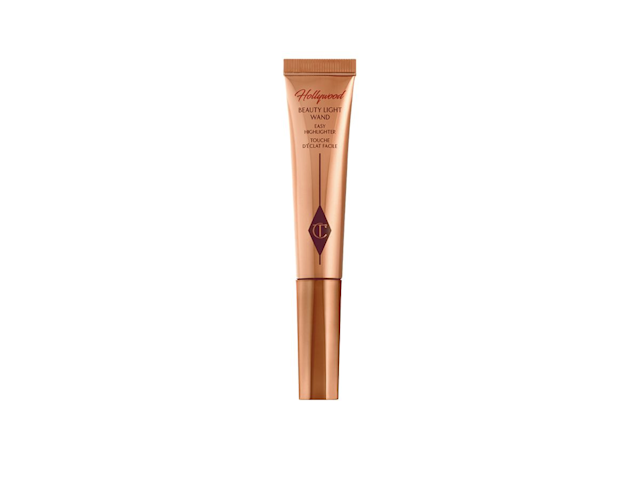 A rose-gold liquid highlighter wand in coppery-gold packaging. 