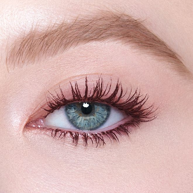 PT - Push Up Lashes Dream Pop Close up Eye Single-eye close-up of a fair-tone model with blue eyes wearing a berry-brown, lengthening mascara that gives her lashes the appearance of false lashes.