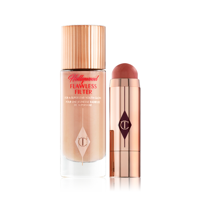 A glow-boosting primer in a light peach colour with an open blush stick in a terracotta colour, both in reflective golden-coloured packaging. 