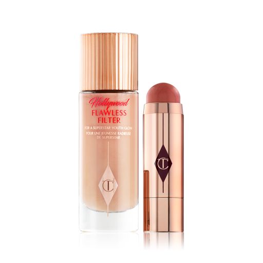 A glow-boosting primer in a light peach colour with an open blush stick in a terracotta colour, both in reflective golden-coloured packaging. 