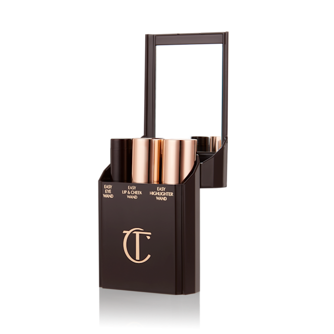 Quick & Easy Instant 5 Minute Look Makeup Kit open An open makeup kit with a mirrored lid with products inside it displayed: a lip and cheek wand, highlighter stick, and eyeshadow stick.