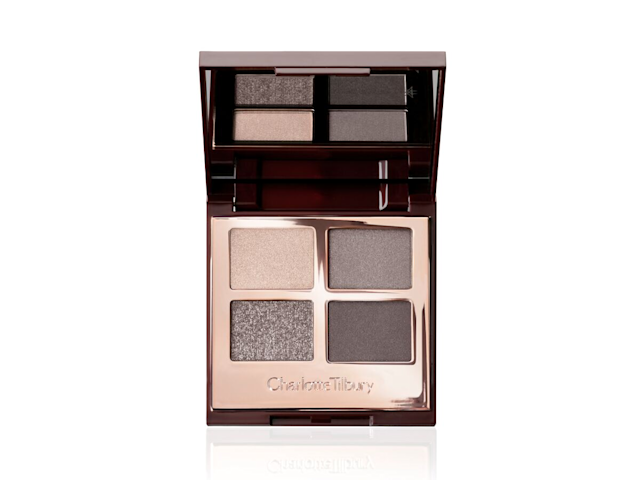 An open, mirrored-lid eyeshadow palette in matte and shimmery silver, grey, and beige shades