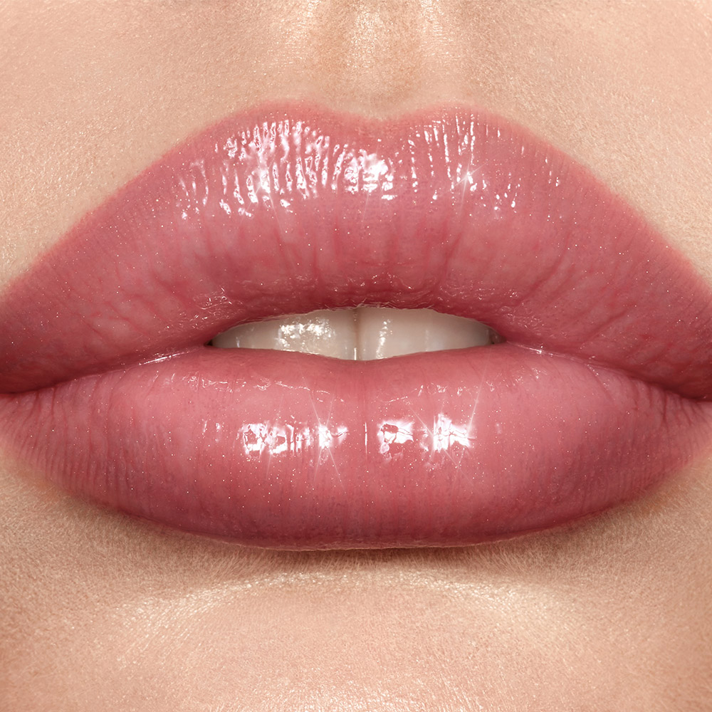 Model wearing nude-pink Lip Lustre lip gloss in Pillow Talk
