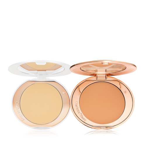Two, open, setting powder compacts with mirrored-lids and white and gold-coloured packaging, in banana yellow and clay-brown shades.