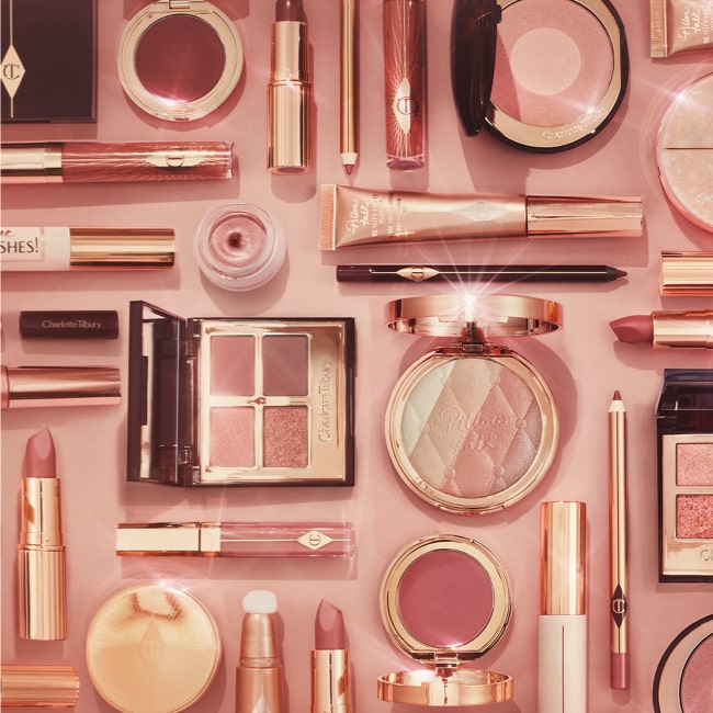 Open, lipsticks in shades of nude pink, medium pink, and dark berry-pink along with matching lip liner pencils, all in sleek, gold-coloured packaging, a two-tone blush compact in medium pink and pearl-pink, a quad eyeshadow compact with a mirrored-lid with pink and brown eye shades in matte and shimmery finishes. 