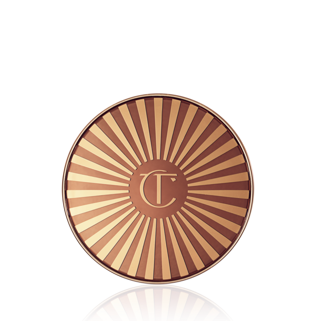 Closed bronzer compact with a golden and brown-coloured lid with the printed logo engraved in the middle. 