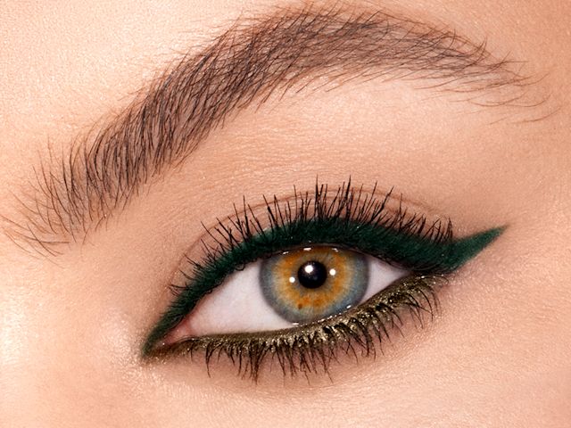 Single eye close-up of a model with hazel eyes wearing bottle-green eyeliner on her upper lid and khaki-green on her lower waterline.