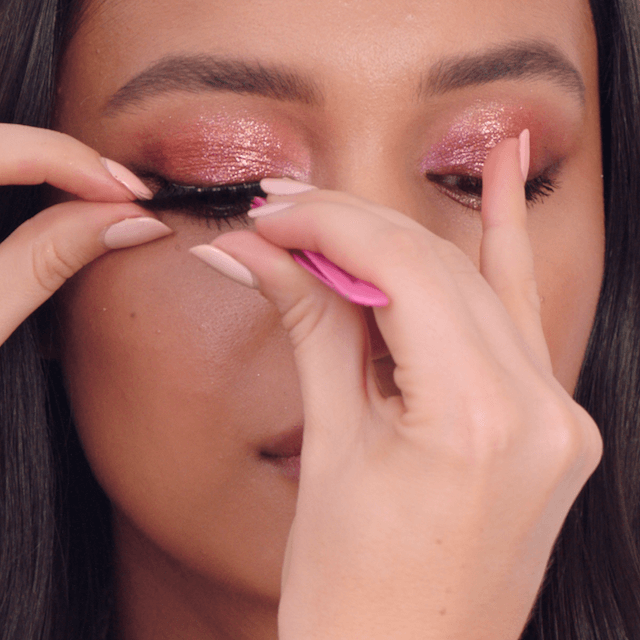Model applying false eyelashes for a bolder lash look