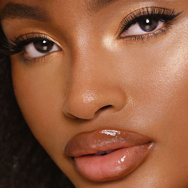 Model wearing Hollywood Glow Glide Face Architect Highlighter in Sunset Glow to create a strobing eye makeup look