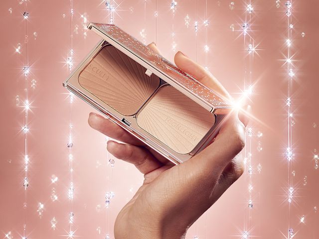 An open, mirrored-lid duo contour palette for light to medium skin tones in sleek rose-gold-coloured packaging held by a medium-tone model.