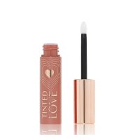 An open tube of lip and cheek tint in a sheer, tea rose colour with a gold-coloured lid and doe-foot applicator.