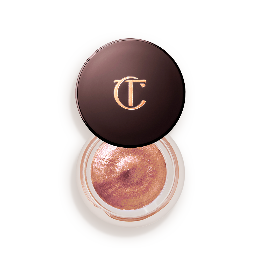 A warm sunset gold cream eyeshadow in a petite, open glass pot with a dark brown lid.