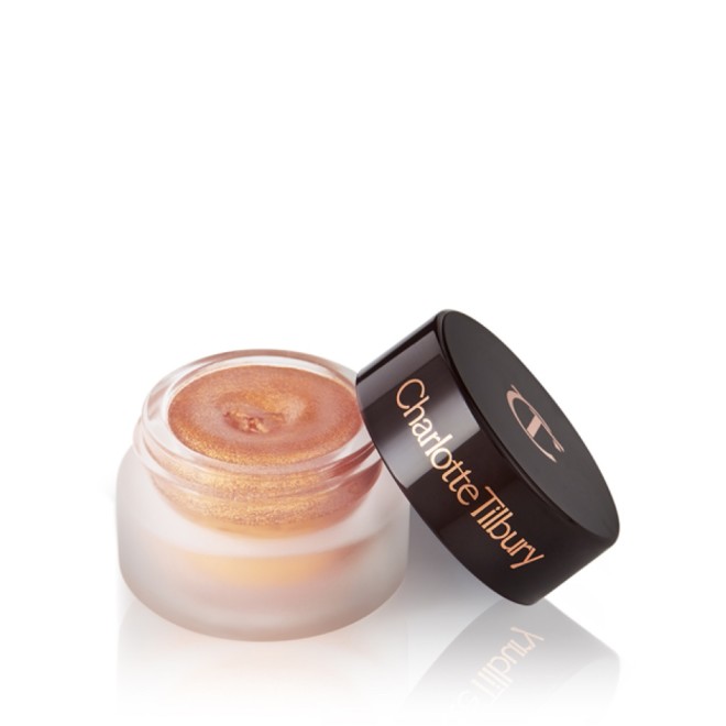 A warm sunset gold cream eyeshadow in a petite, open glass pot with a dark brown lid.