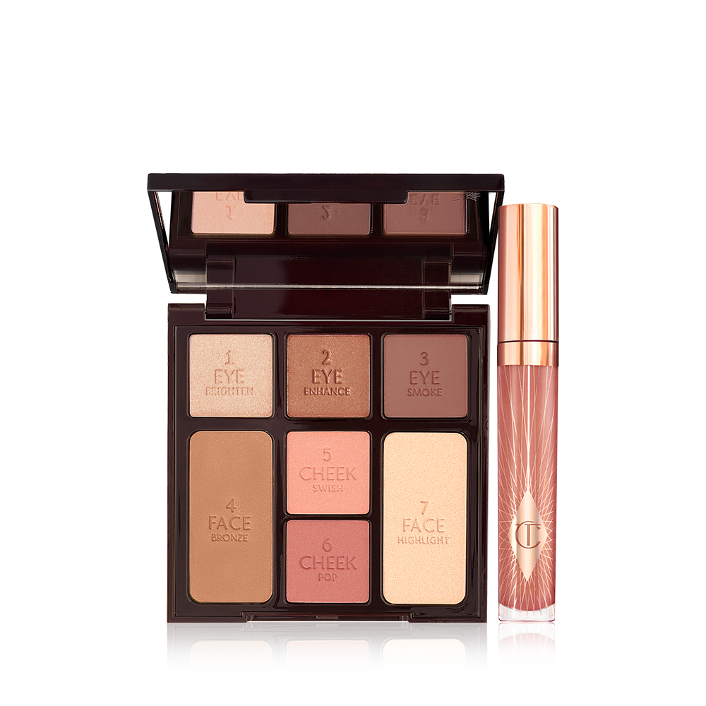 An open, mirrored-lid face palette with nude eyeshadows, nude pink and berry-pink blushes, light brown bronzer, and champagne highlighter with a nude pink lip gloss in a glass tube with a gold-coloured lid.
