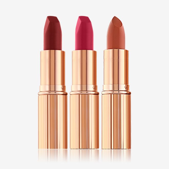 Your Lip Service lipstick trio open Two matte lipsticks and one satin-finish lipstick in scarlet, fuchsia, and dark terracotta.