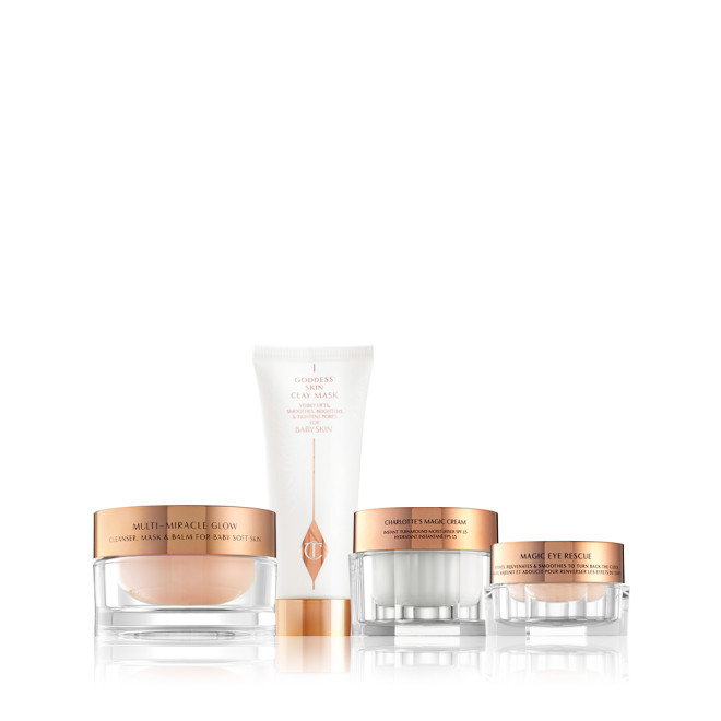 A champagne-coloured night cream, a pearly-white face cream, and a light champagne eye cream, all in glass jars with rose-gold lids with a clay mask in white and rose-gold packaging. 